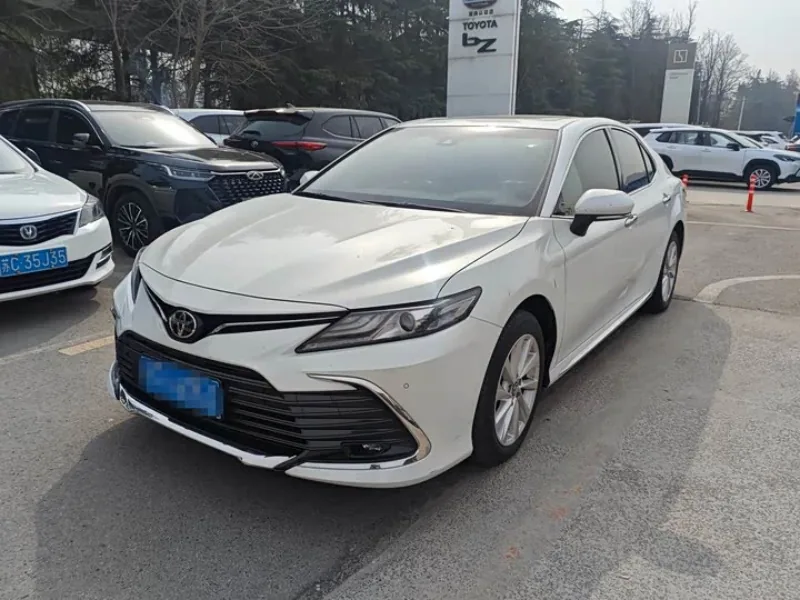 White Toyota Camry reference vehicle viewed from the front in a parking area